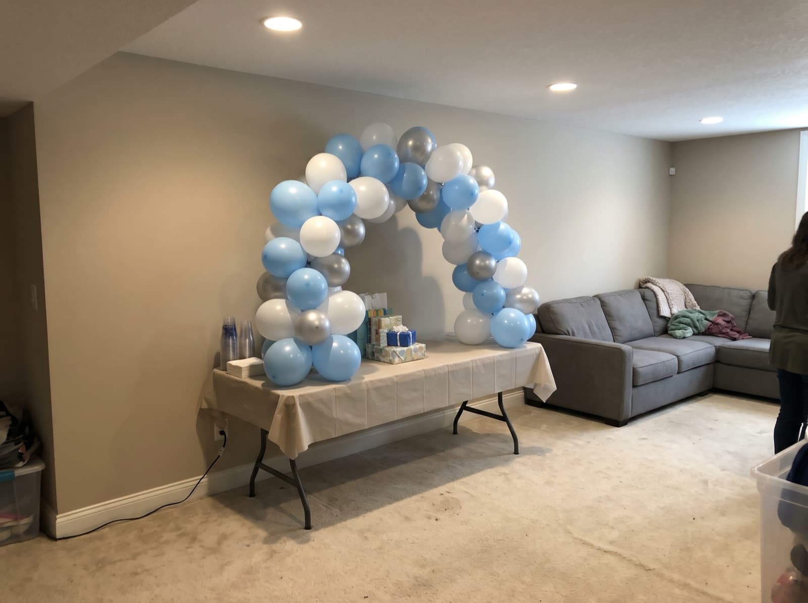 Mini tabletop balloon arch over a gift table in a finished basement